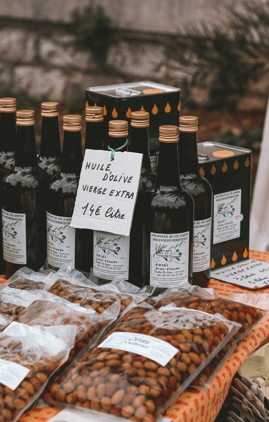 Bottiglie di olio d'oliva e olive in vendita a uno stand del mercato.